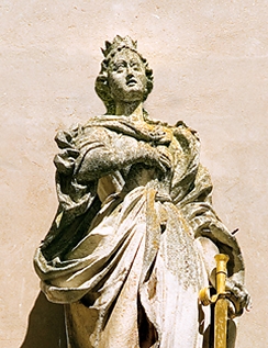 Barocke Figur der Kirchenpatronin St. Katharina über dem westlichen Hauptportal